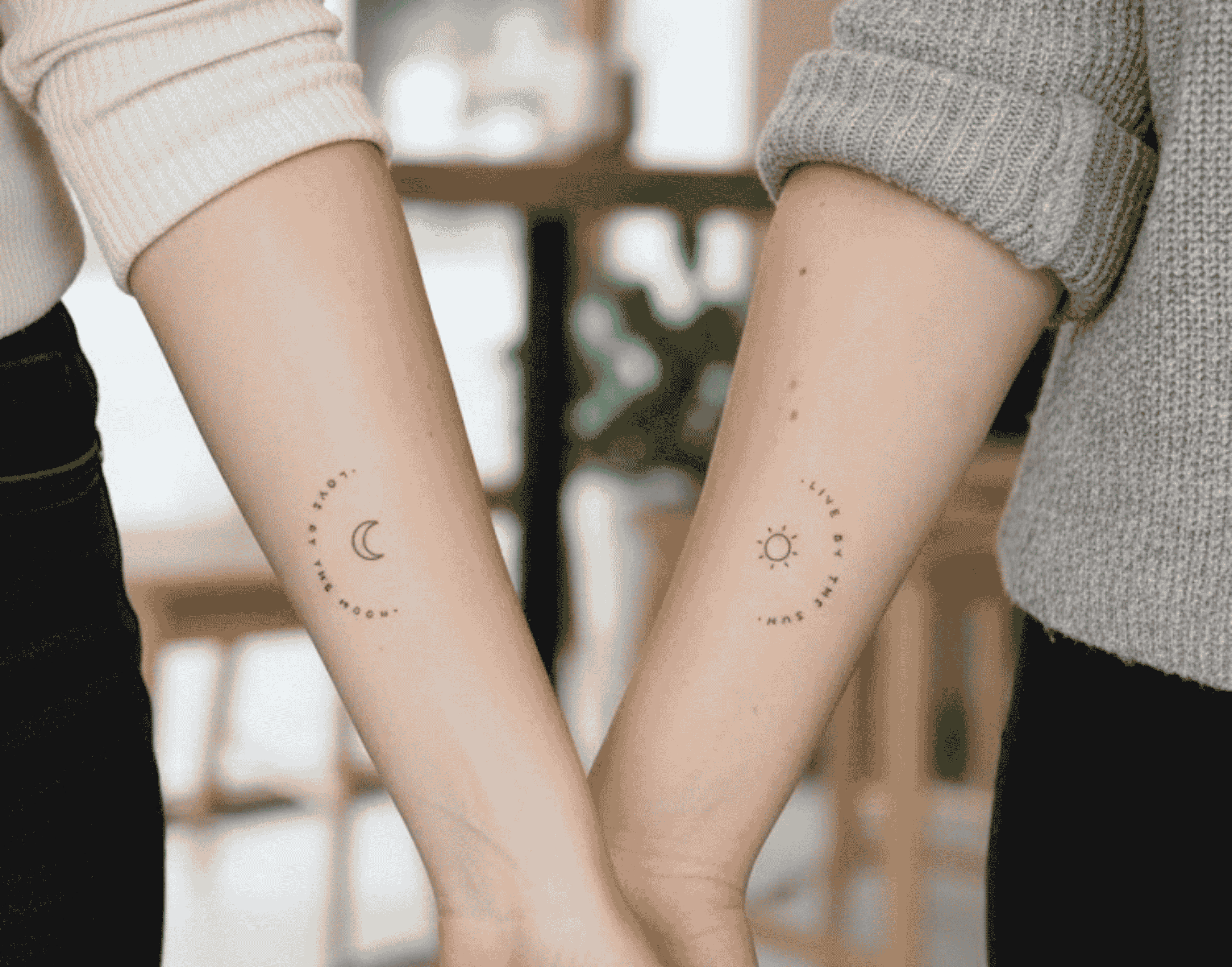 Brazos de un par de mujeres con tatuajes iguales